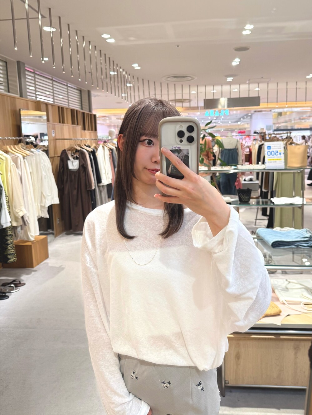 ホワイト系のTシャツ/カットソー、ベージュ系のスカート、シルバー系のトートバッグを着用したレディースの夏コーディネートの2枚目の写真