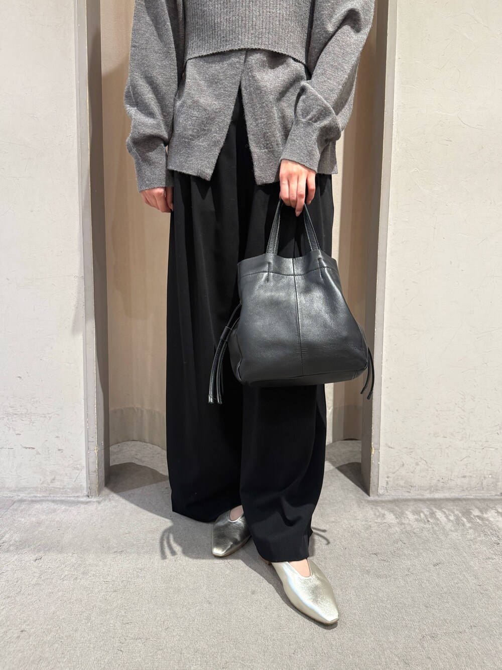 グレー系のカーディガン/ボレロ、ゴールド系のパンプス、ブラック系のトートバッグを着用したレディースの秋コーディネートの3枚目の写真