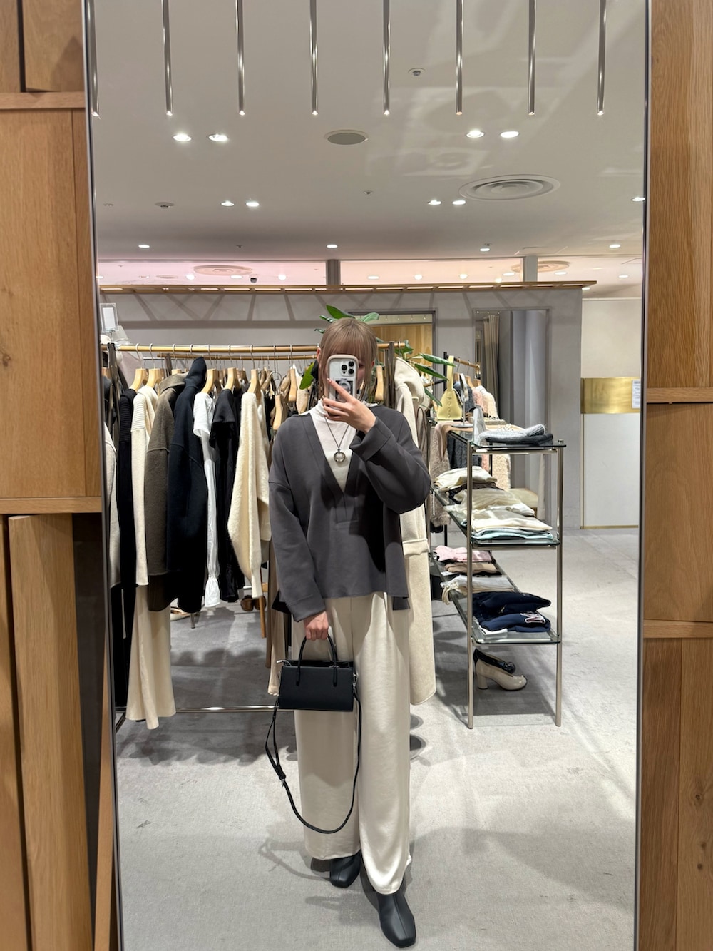 グレー系のスウェット、ホワイト系のTシャツ/カットソー、ブラック系のトートバッグを着用したレディースの冬コーディネートの3枚目の写真