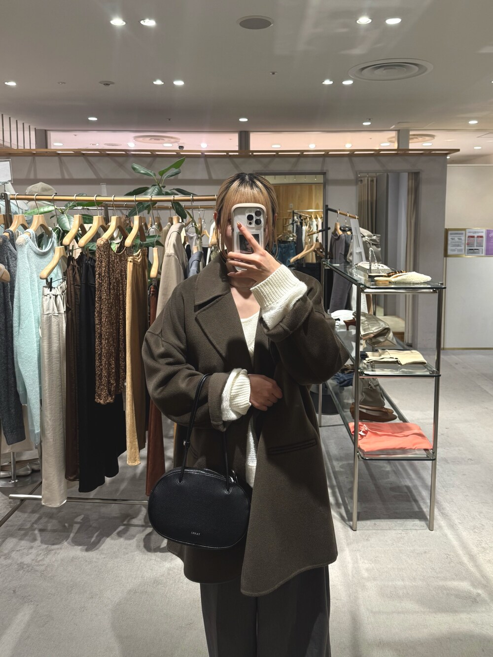 ホワイト系のニット/セーター、ブラウン系のその他アウター、シルバー系のネックレスを着用したレディースの秋コーディネートの3枚目の写真