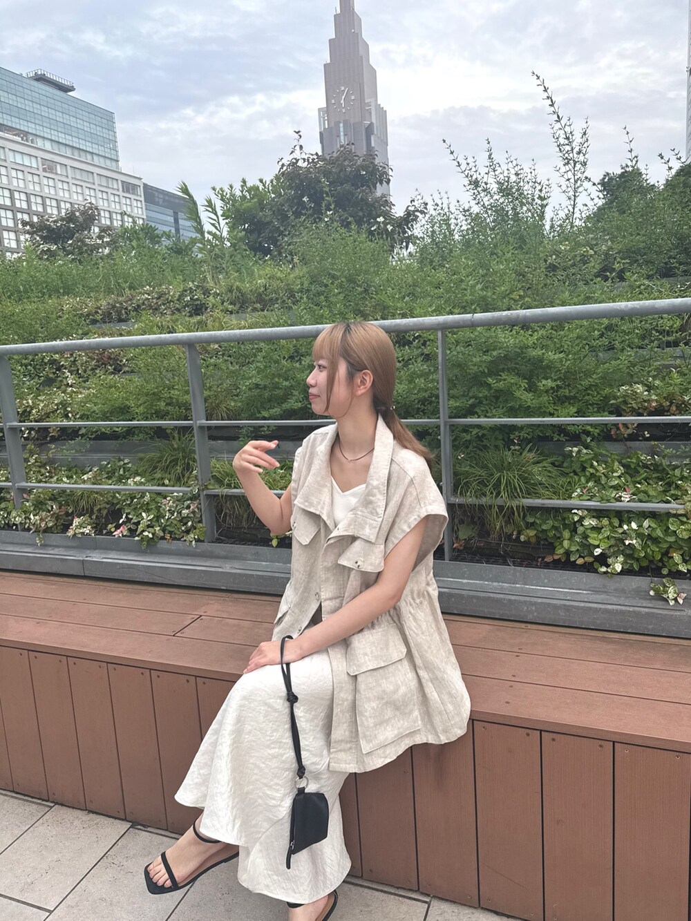 ホワイト系のキャミソール、ベージュ系のベスト、ホワイト系のスカートを着用したレディースの夏コーディネートの3枚目の写真