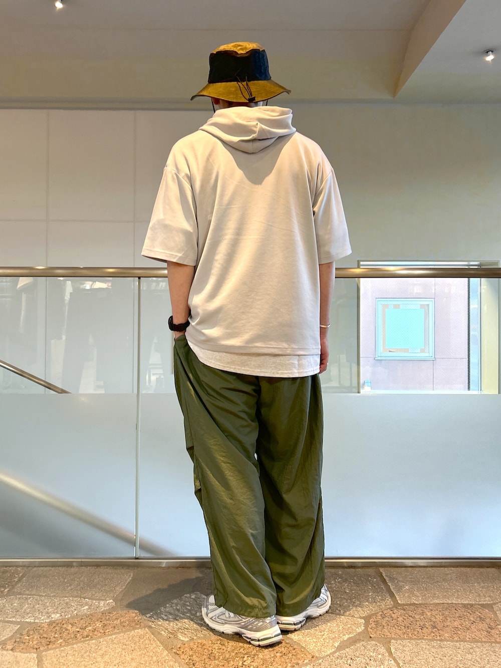 グレー系のTシャツ/カットソー、グリーン系のカーゴパンツを着用したメンズの夏コーディネートの3枚目の写真