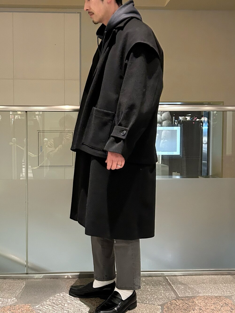 ブラック系のトレンチコート、グレー系のデニムパンツを着用したメンズの冬コーディネートの3枚目の写真