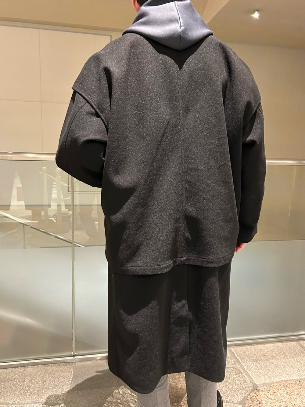 ブラック系のトレンチコート、グレー系のデニムパンツを着用したメンズの冬コーディネートの5枚目の写真