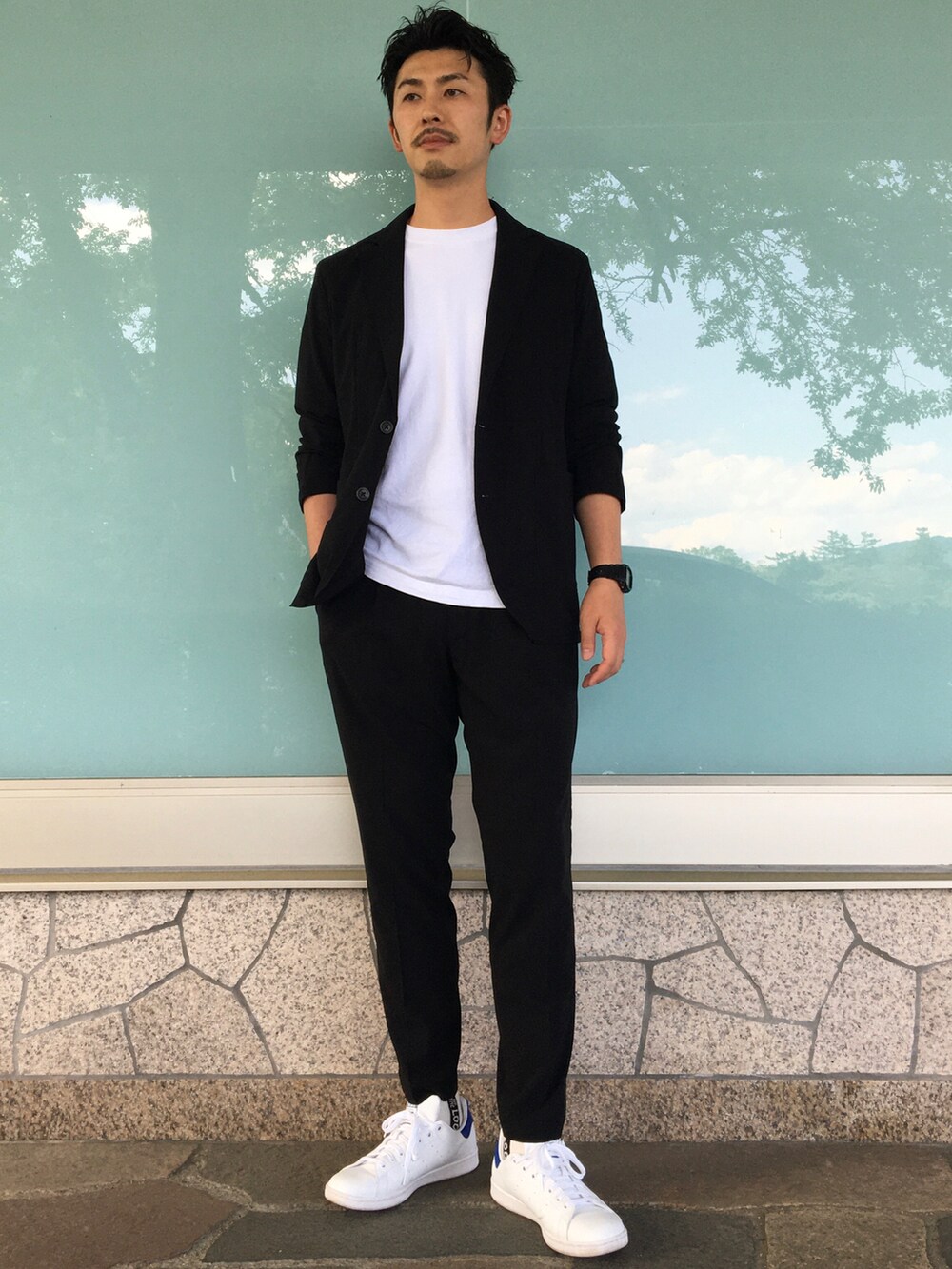 ブラック系のテーラードジャケット、ブラック系のスラックス、ホワイト系のTシャツ/カットソーを着用したメンズの夏コーディネートの2枚目の写真