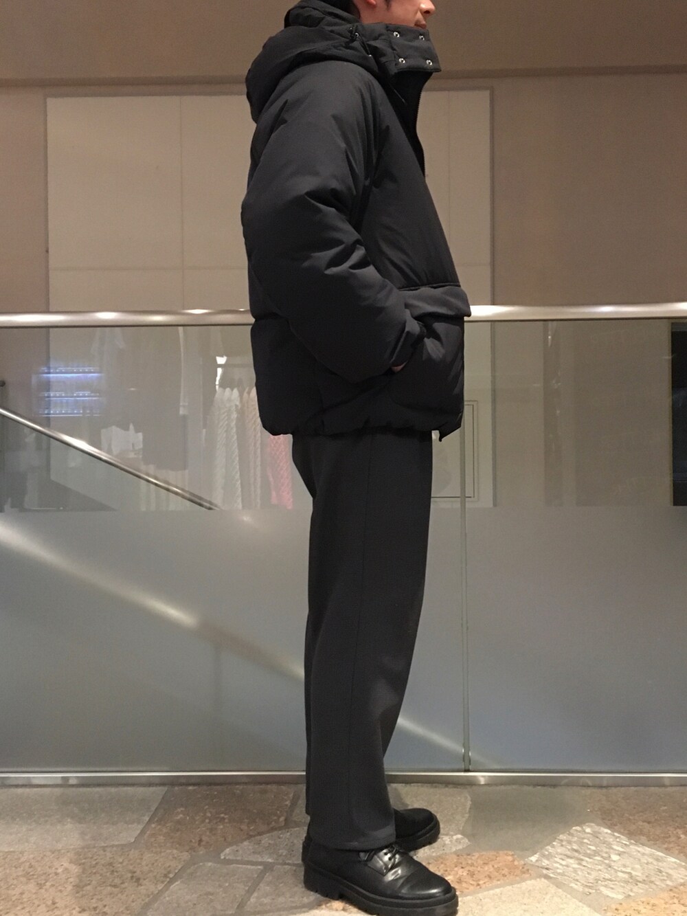 ブラック系のスウェット、ブラック系のダウンジャケット/コート、グレー系のスラックスを着用したメンズの冬コーディネートの2枚目の写真