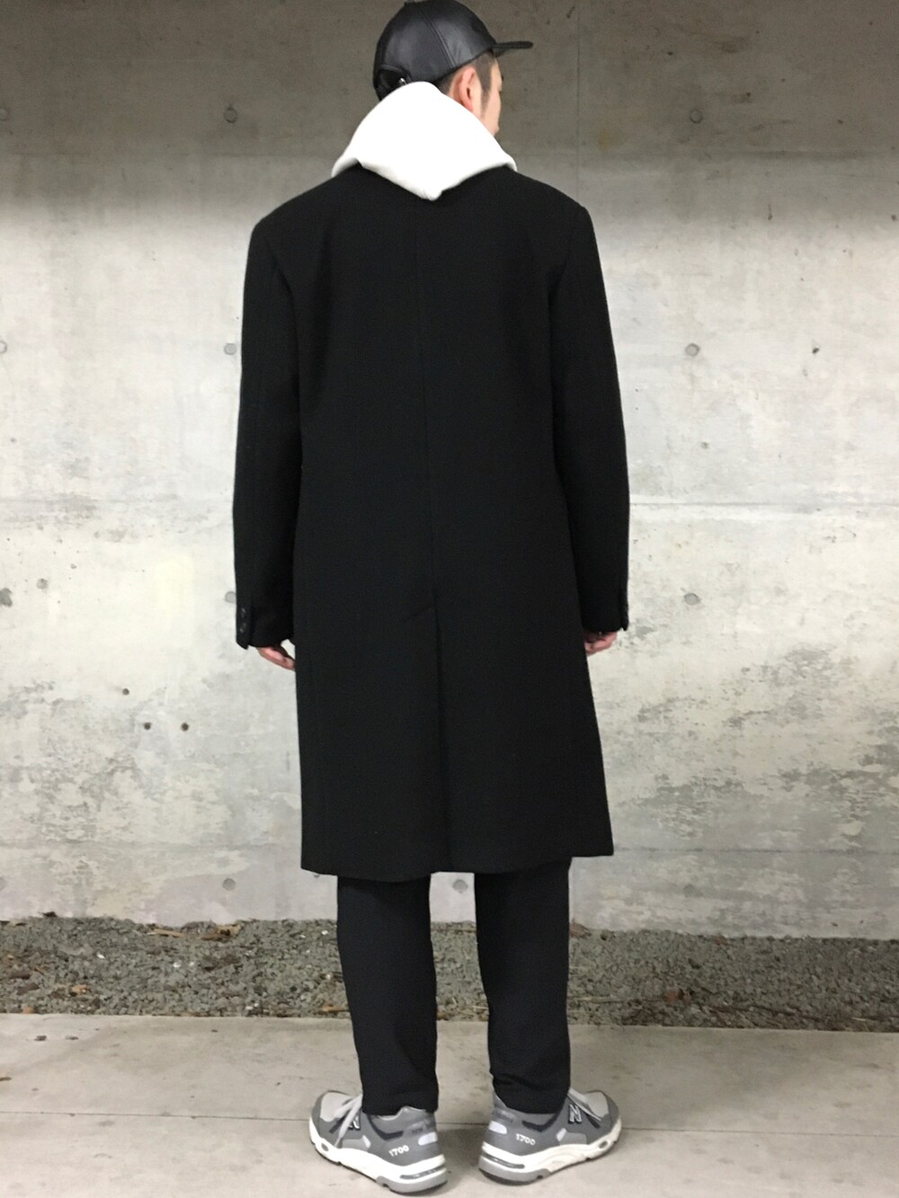 ブラック系のニット/セーター、ホワイト系のパーカー、ブラック系のチェスターコートを着用したメンズの冬コーディネートの2枚目の写真