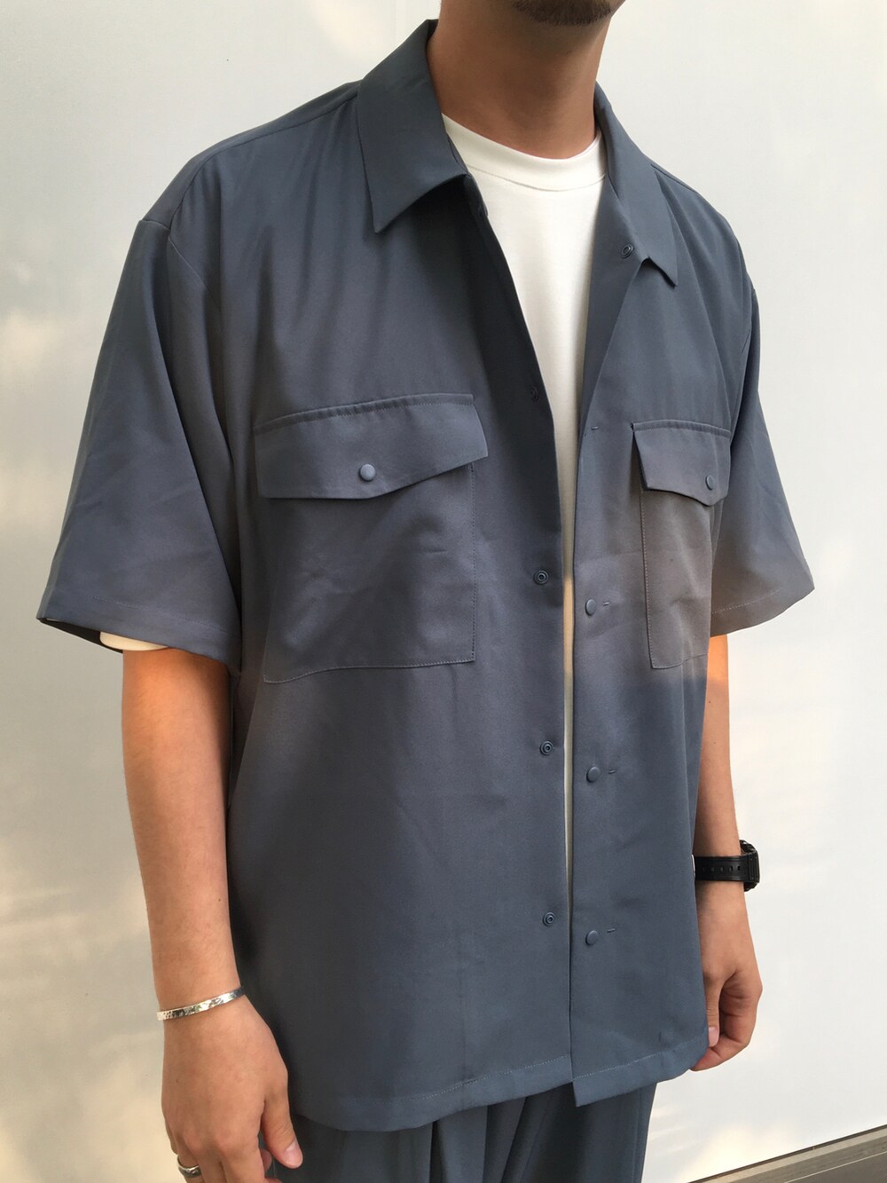 ブルー系のシャツ/ブラウス、ホワイト系のTシャツ/カットソー、ブルー系のスラックスを着用したメンズの春コーディネートの2枚目の写真