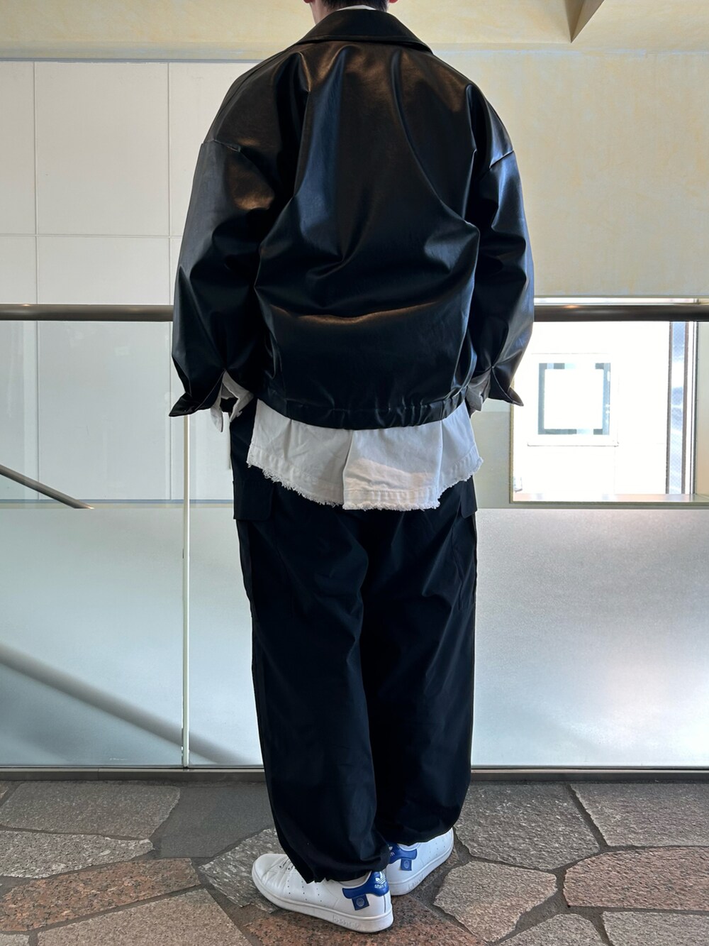 ブラック系のブルゾン、ホワイト系のシャツ/ブラウス、ブラック系のカーゴパンツを着用したメンズの春コーディネートの2枚目の写真