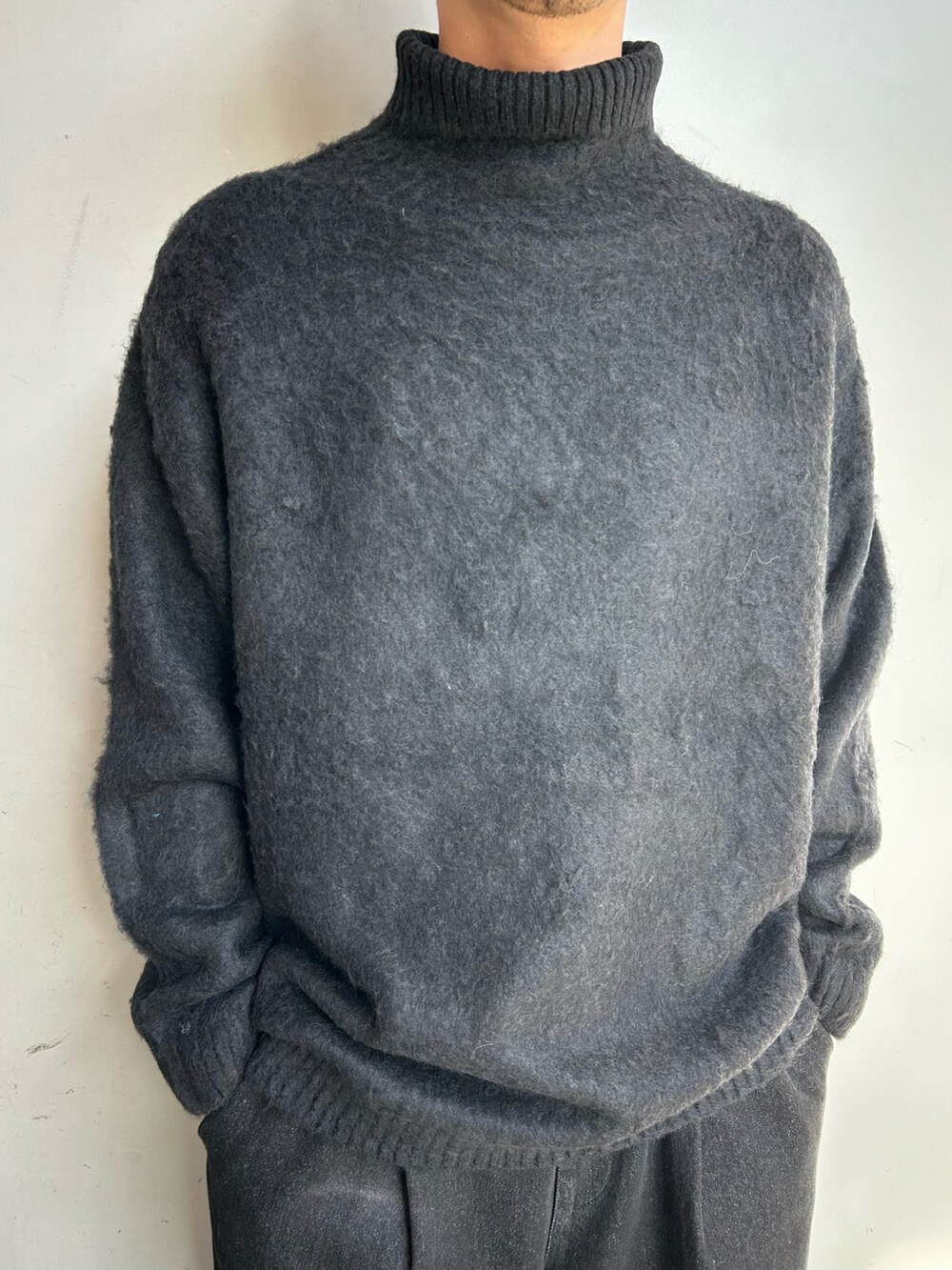 ブラック系のニット/セーター、ブラック系のデニムパンツを着用したメンズの冬コーディネートの2枚目の写真