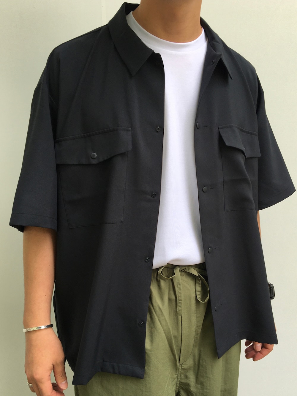 ブラック系のシャツ/ブラウス、ホワイト系のTシャツ/カットソー、グリーン系のカーゴパンツを着用したメンズの夏コーディネートの4枚目の写真