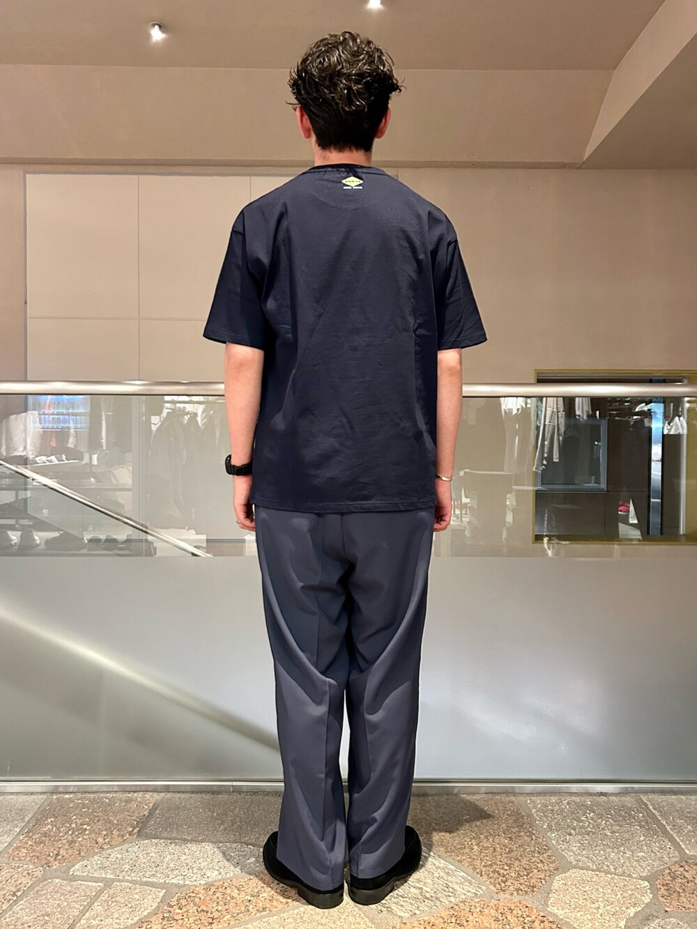 ブルー系のTシャツ/カットソー、ブルー系のスラックスを着用したメンズの夏コーディネートの2枚目の写真