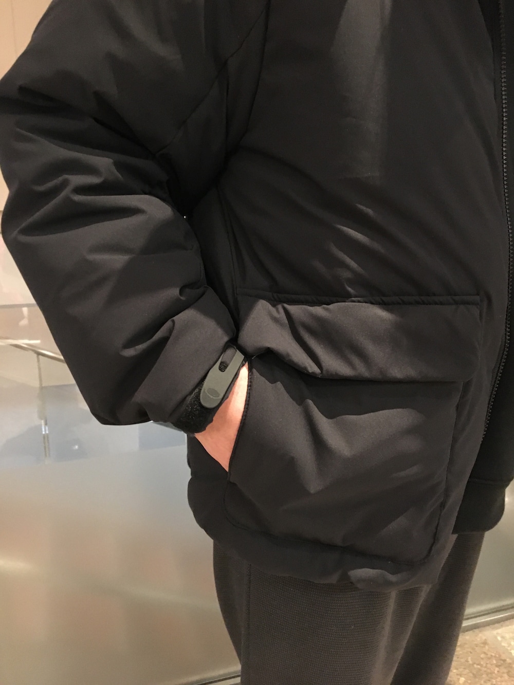 ブラック系のスウェット、ブラック系のダウンジャケット/コート、グレー系のスラックスを着用したメンズの冬コーディネートの5枚目の写真