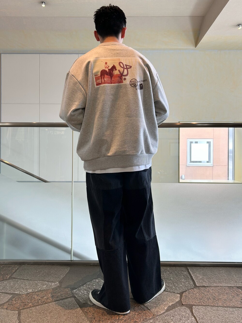 ホワイト系のスウェット、ブラック系のデニムパンツを着用したメンズの春コーディネートの2枚目の写真