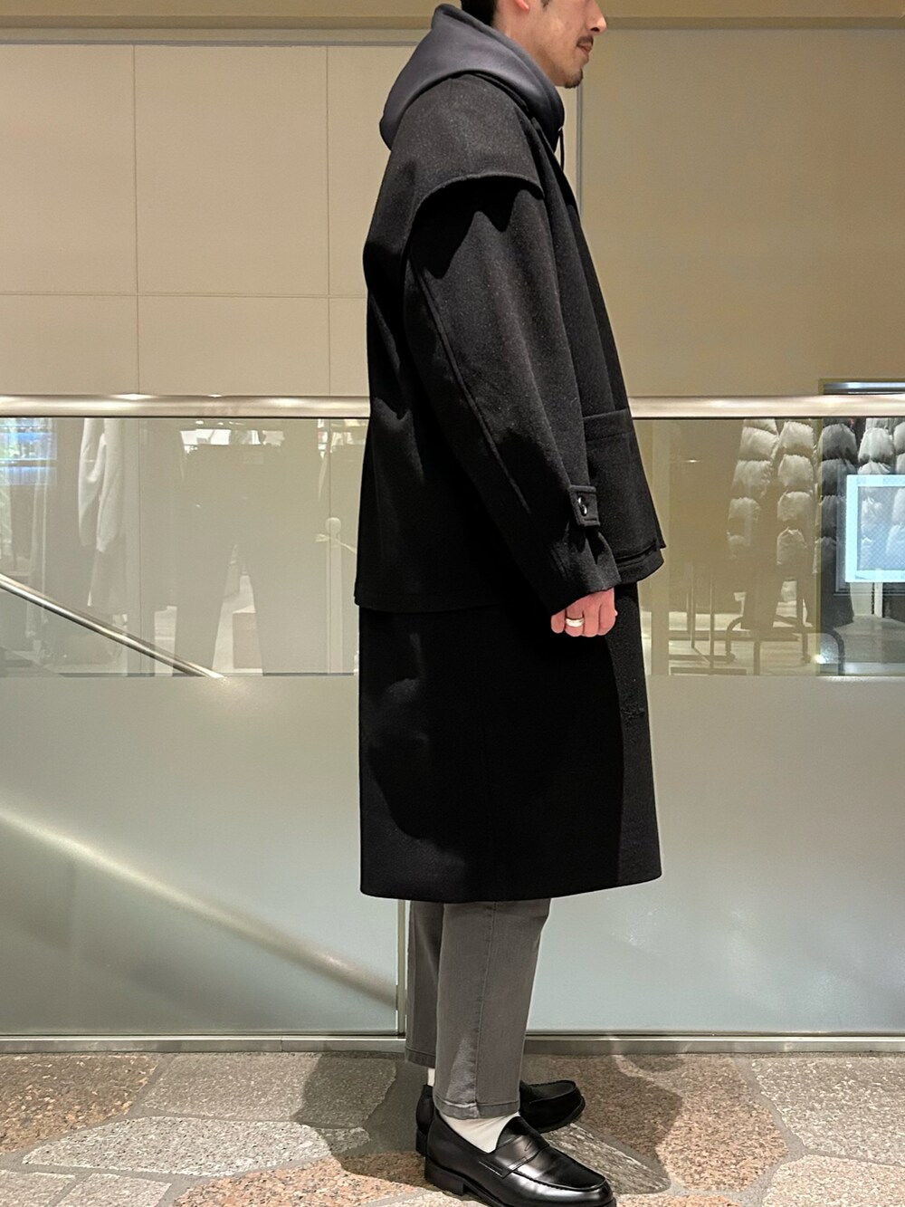 ブラック系のトレンチコート、グレー系のデニムパンツを着用したメンズの冬コーディネートの2枚目の写真