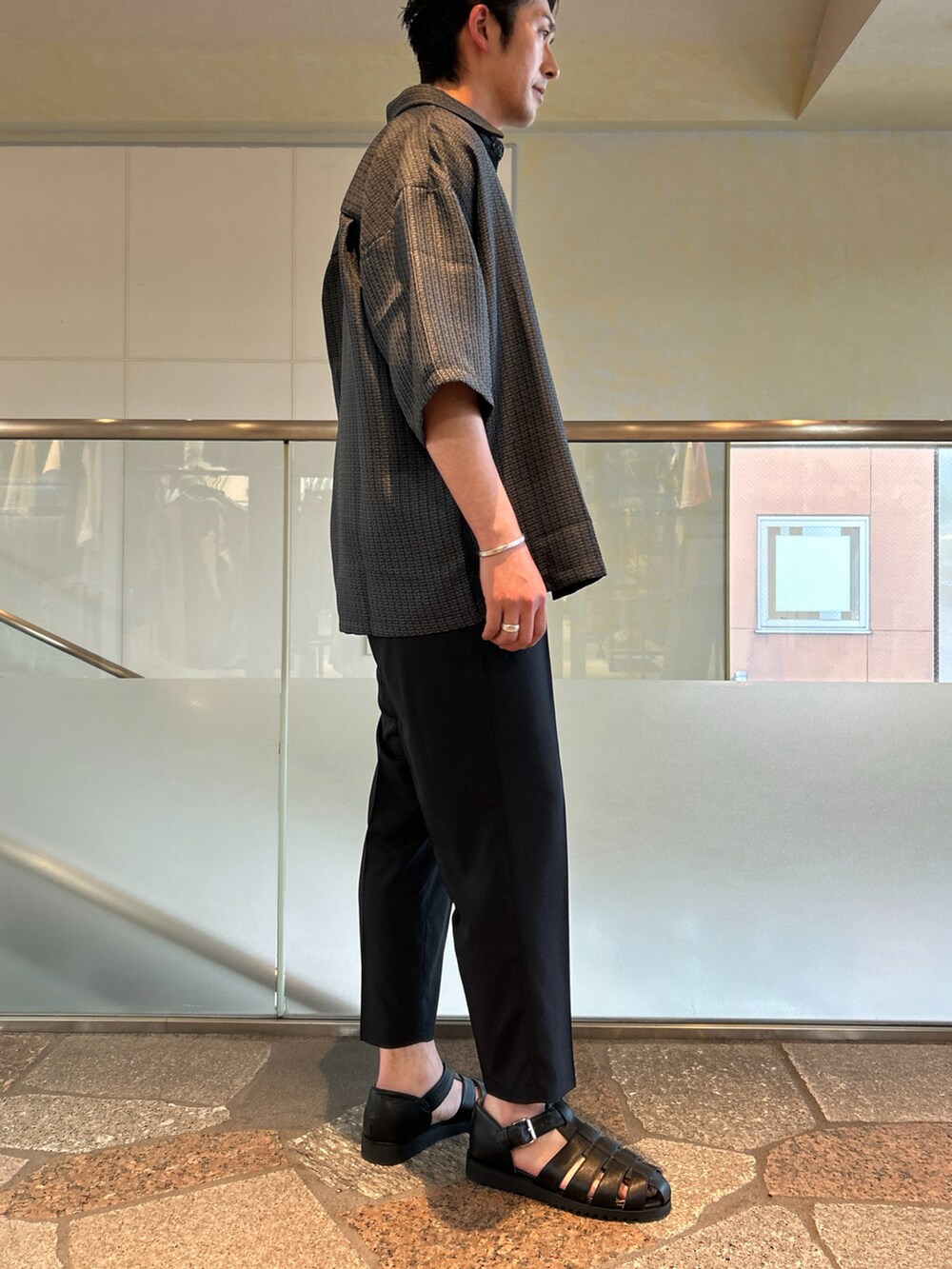 ブラック系のシャツ/ブラウス、ブラック系のスラックス、ブラック系のタンクトップを着用したメンズの春コーディネートの2枚目の写真