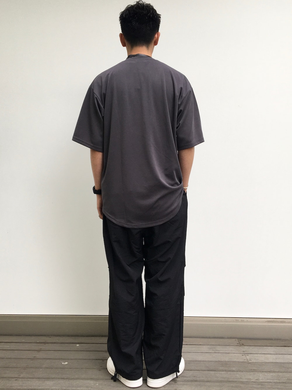 グレー系のTシャツ/カットソー、ブラック系のショルダーバッグ、ブラック系のカーゴパンツを着用したメンズの夏コーディネートの2枚目の写真