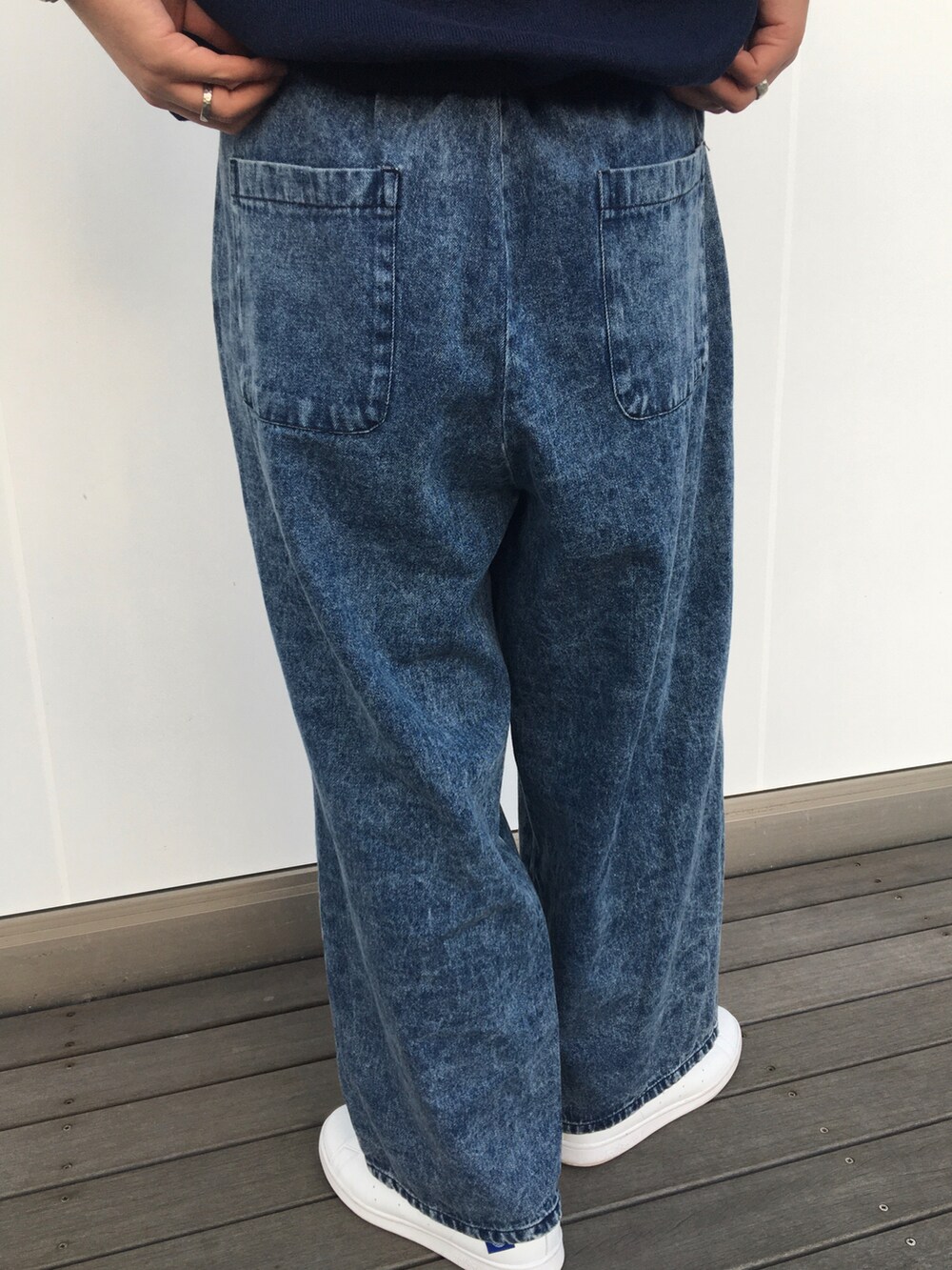 ブルー系のニット/セーター、ブルー系のデニムパンツ、ホワイト系のスニーカーを着用したメンズの春コーディネートの4枚目の写真