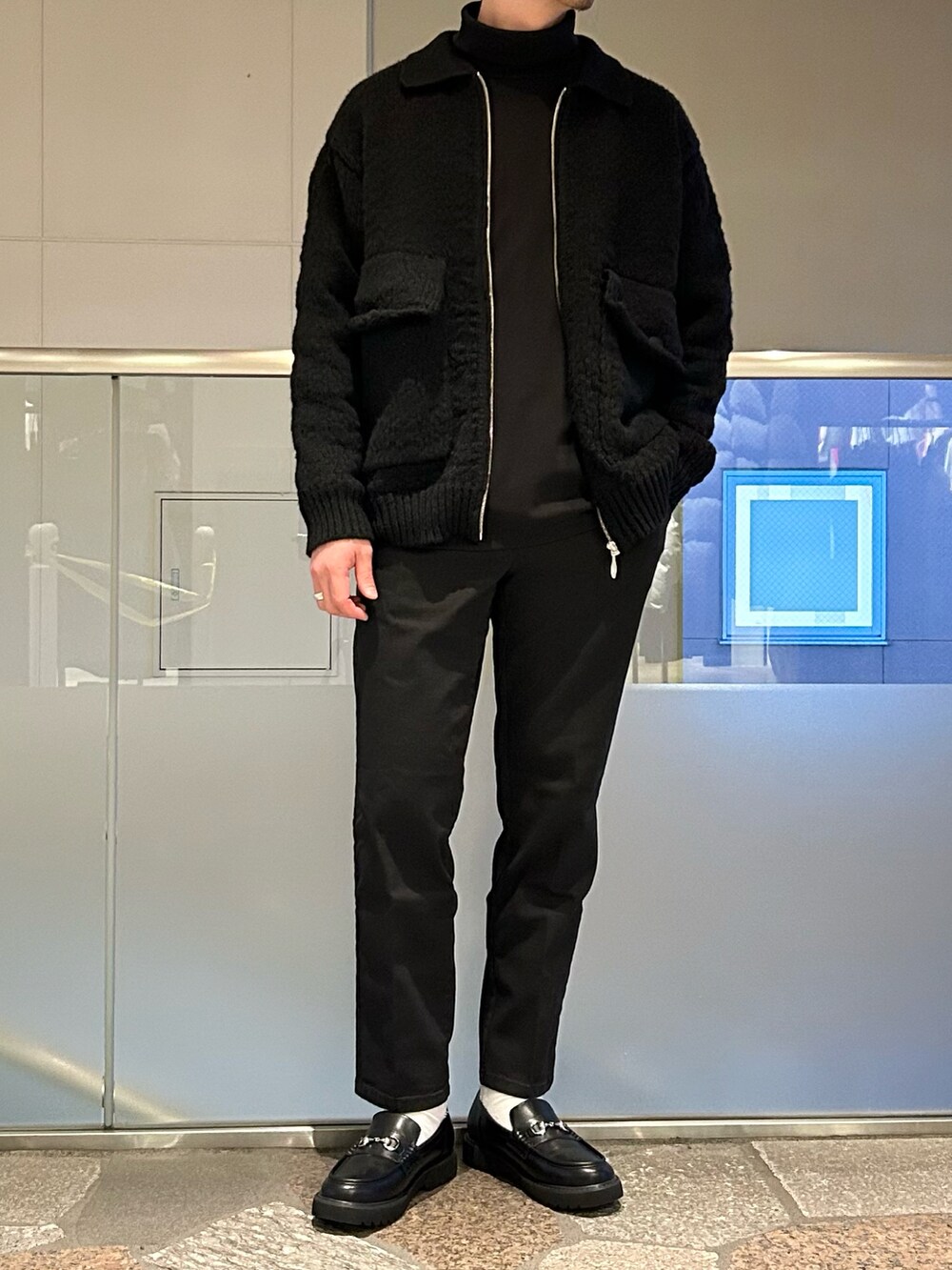 ブラック系のブルゾン、ブラック系のTシャツ/カットソー、ブラック系のデニムパンツを着用したメンズの冬コーディネートの2枚目の写真