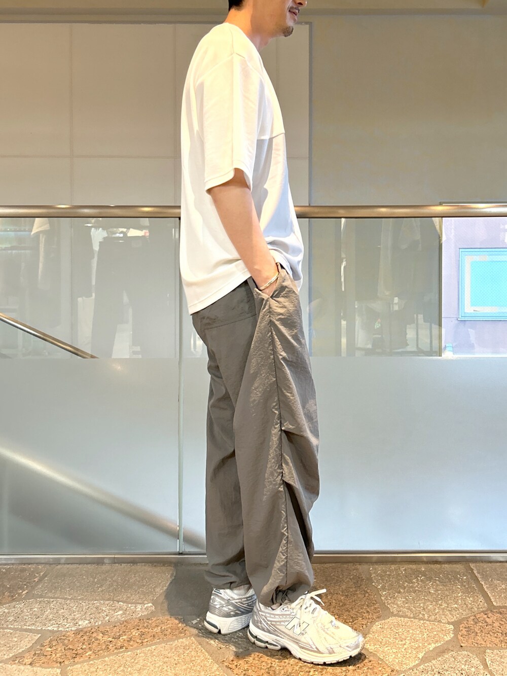 ホワイト系のTシャツ/カットソー、グレー系のカーゴパンツを着用したメンズの夏コーディネートの2枚目の写真