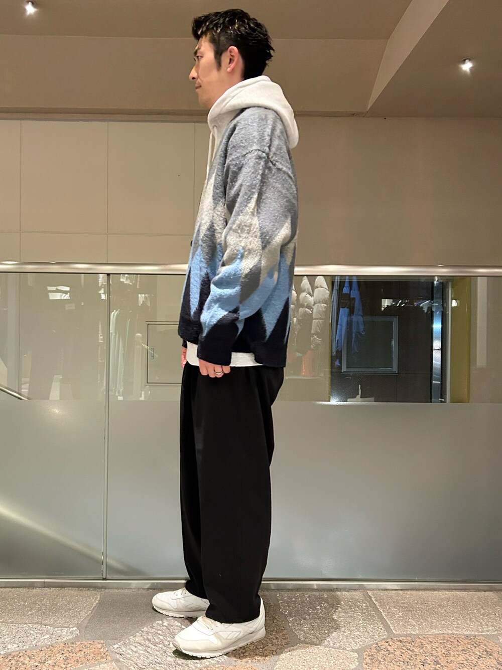 グレー系のパーカー、グレー系のカーディガン/ボレロ、ベージュ系のスラックスを着用したメンズの冬コーディネートの2枚目の写真