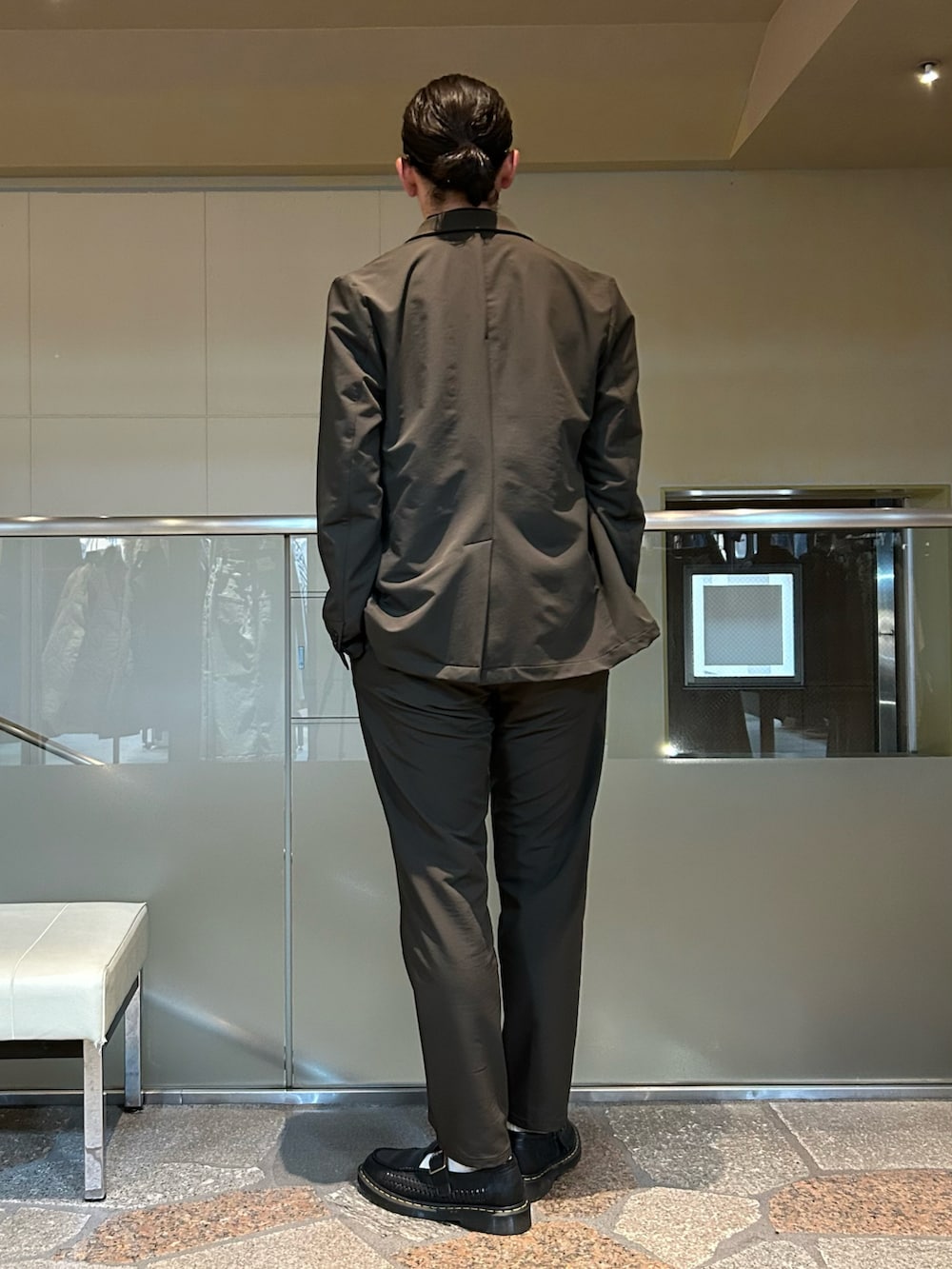 グリーン系のテーラードジャケット、グリーン系のスラックスを着用したメンズの秋コーディネートの5枚目の写真