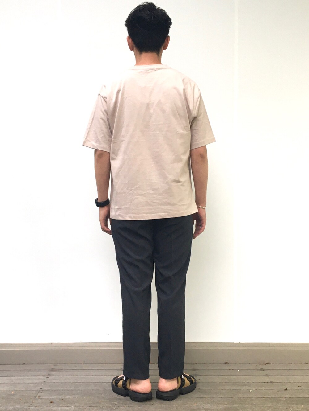ベージュ系のTシャツ/カットソー、ブラック系のスラックスを着用したメンズの春コーディネートの3枚目の写真