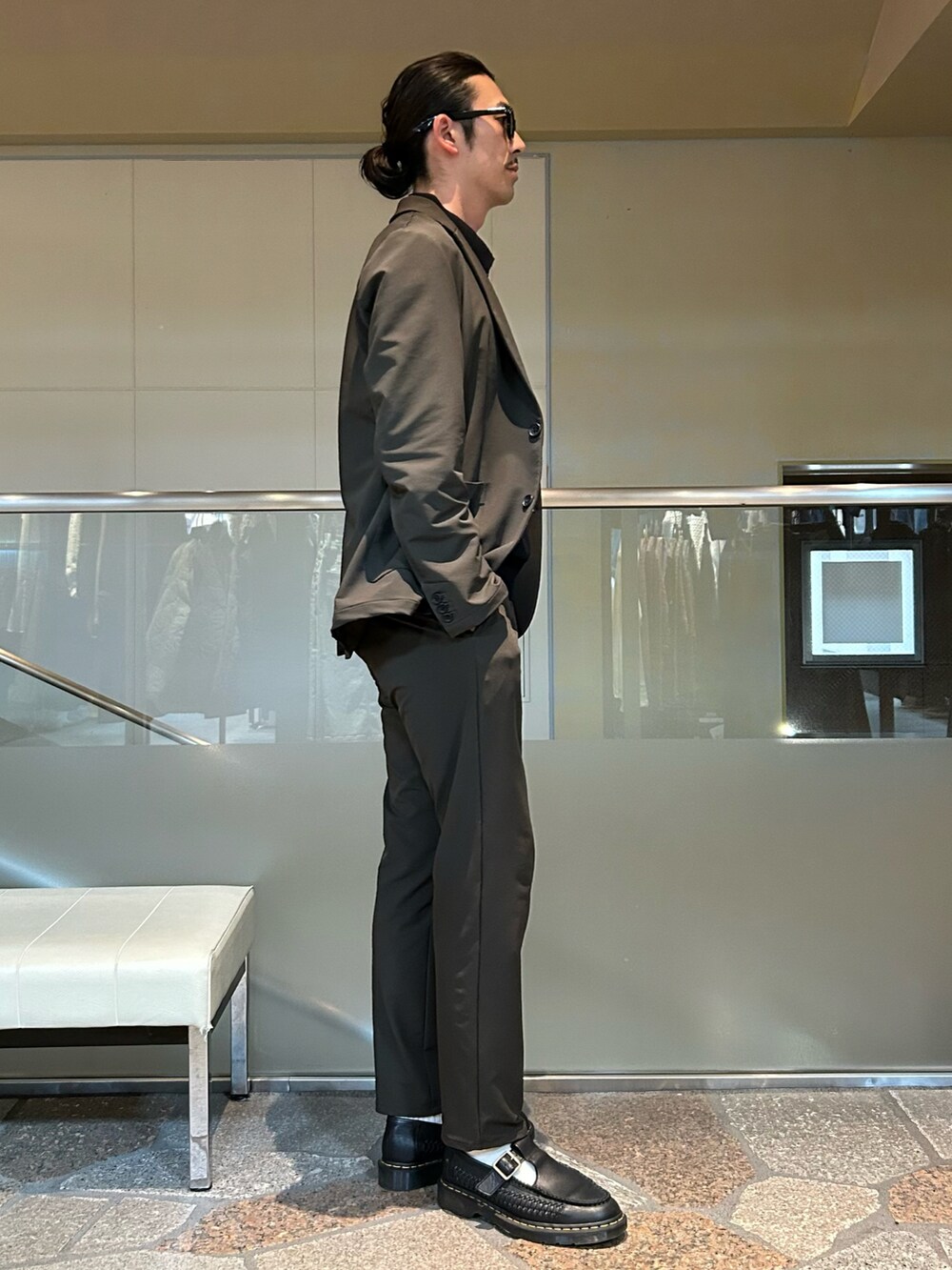 グリーン系のテーラードジャケット、グリーン系のスラックスを着用したメンズの秋コーディネートの4枚目の写真