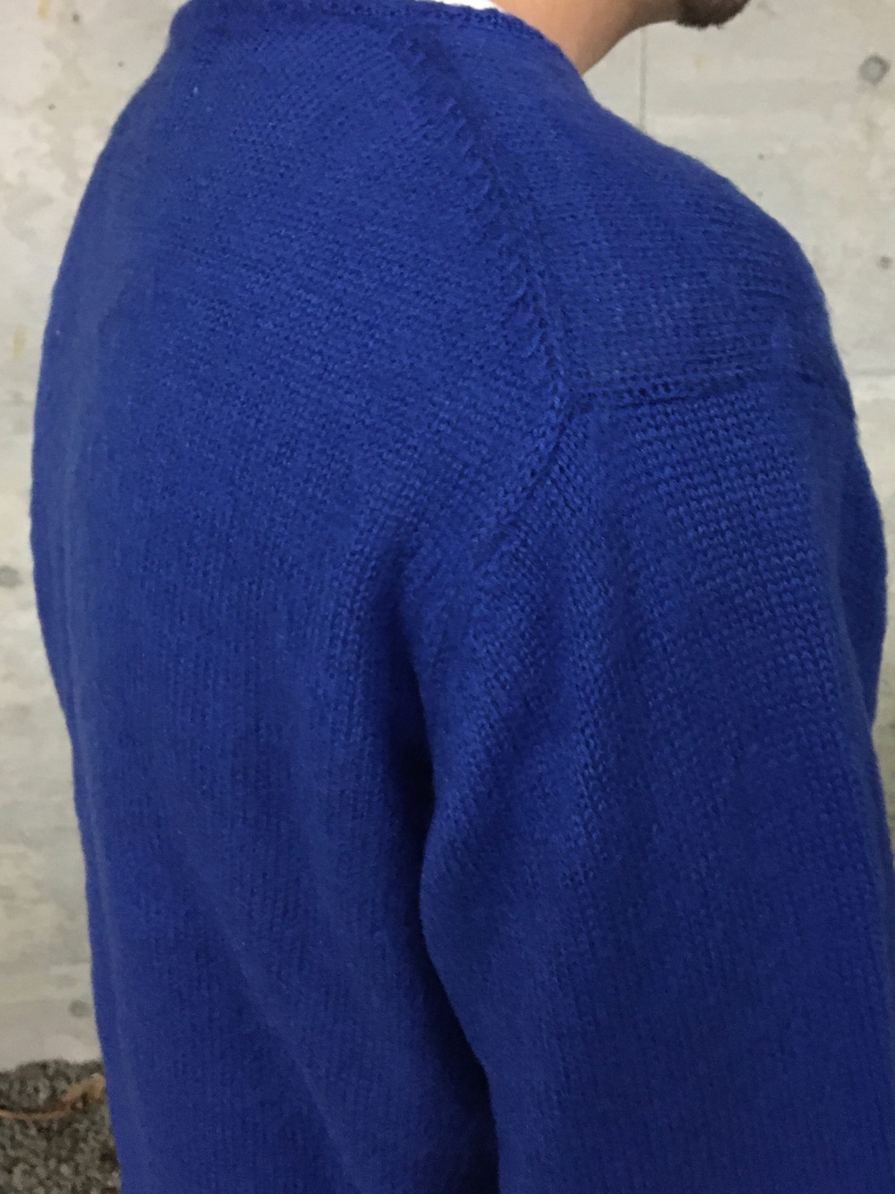 ブルー系のニット/セーター、ブルー系のデニムパンツを着用したメンズの冬コーディネートの4枚目の写真