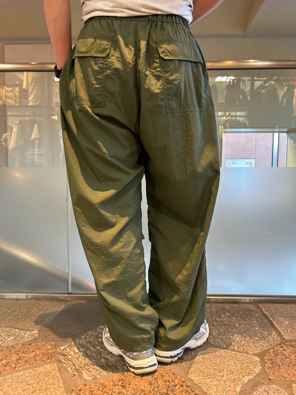 グレー系のTシャツ/カットソー、グリーン系のカーゴパンツを着用したメンズの夏コーディネートの5枚目の写真