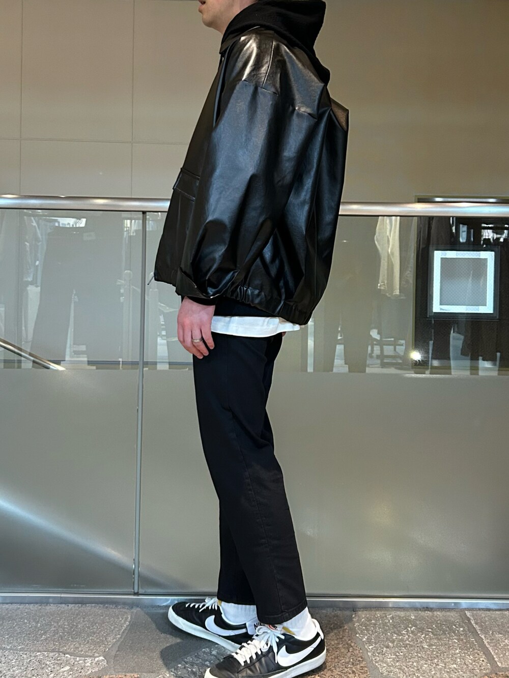 ブラック系のブルゾン、ブラック系のパーカー、ホワイト系のTシャツ/カットソーを着用したメンズの春コーディネートの2枚目の写真
