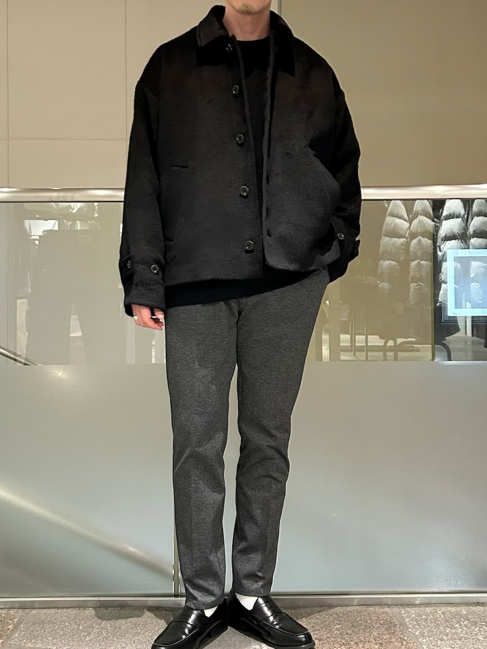 ブラック系のブルゾン、ブラック系のTシャツ/カットソー、グレー系のパンツを着用したメンズの冬コーディネートの2枚目の写真