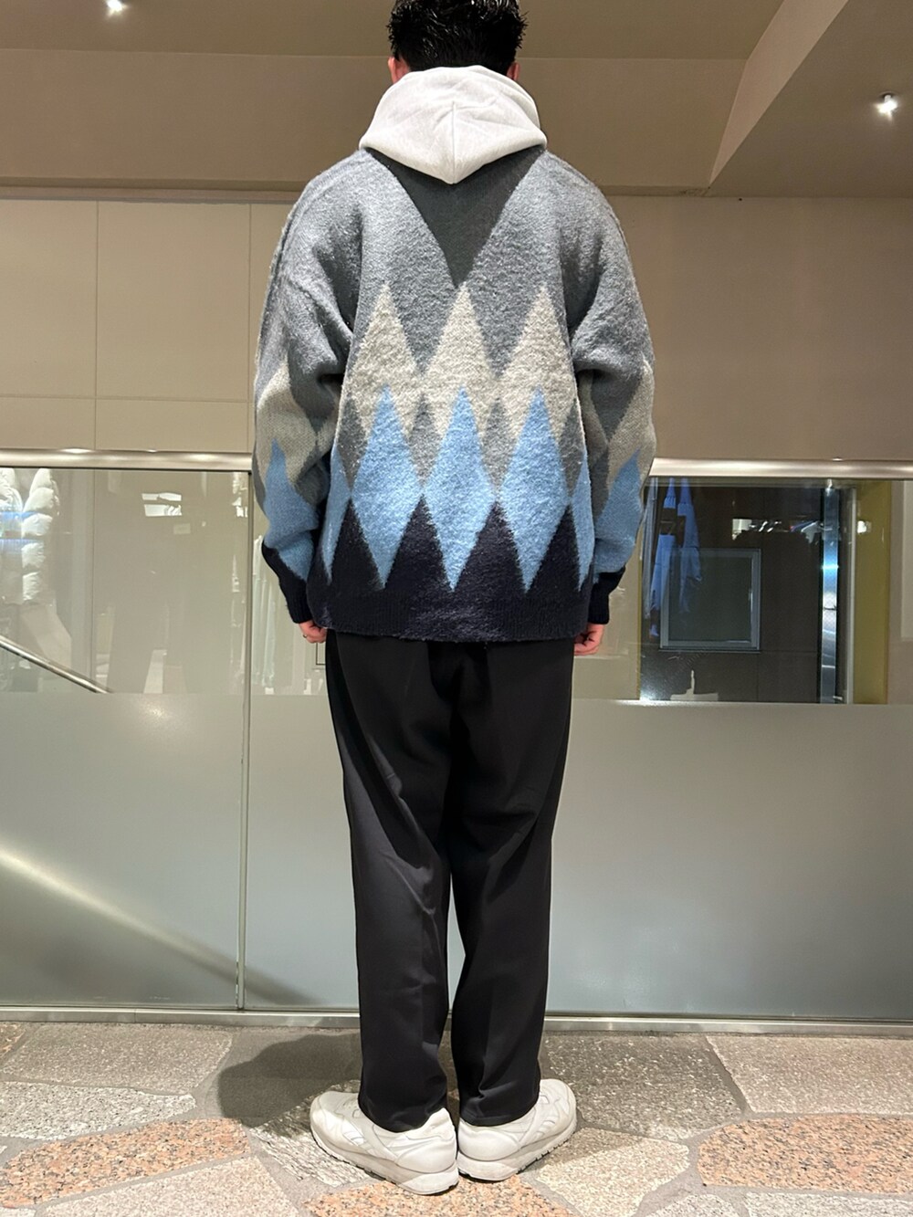 グレー系のパーカー、グレー系のカーディガン/ボレロ、ベージュ系のスラックスを着用したメンズの冬コーディネートの3枚目の写真