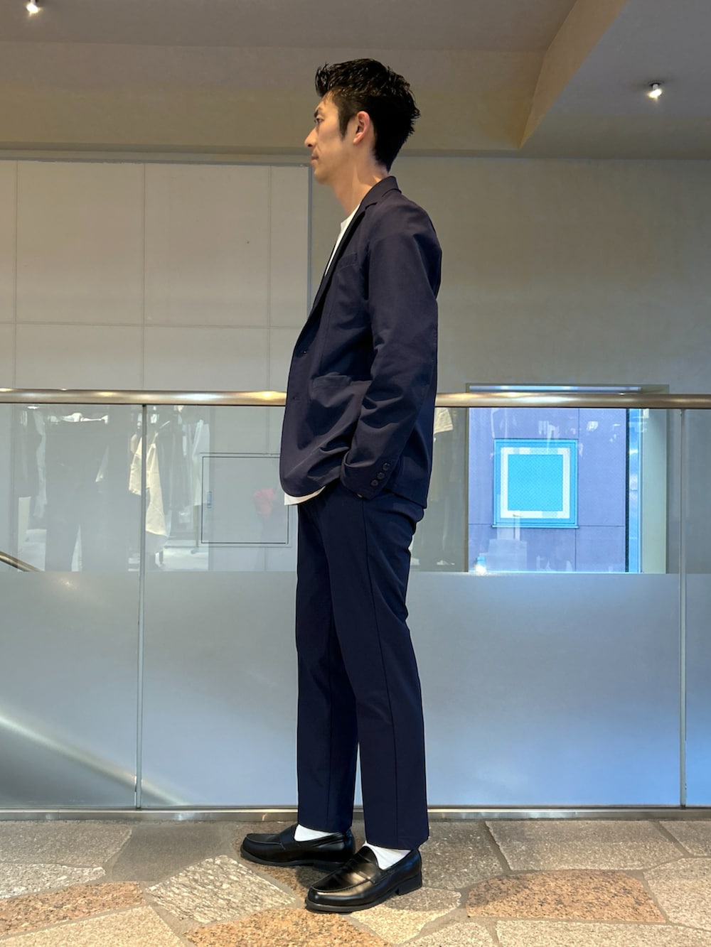 ブルー系のテーラードジャケット、ホワイト系のTシャツ/カットソー、ブルー系のスラックスを着用したメンズの春コーディネートの2枚目の写真