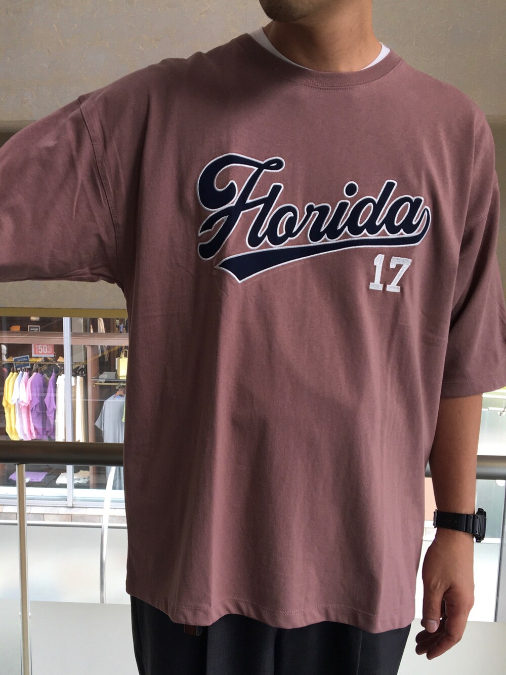 ピンク系のTシャツ/カットソー、グレー系のスラックスを着用したメンズの夏コーディネートの2枚目の写真