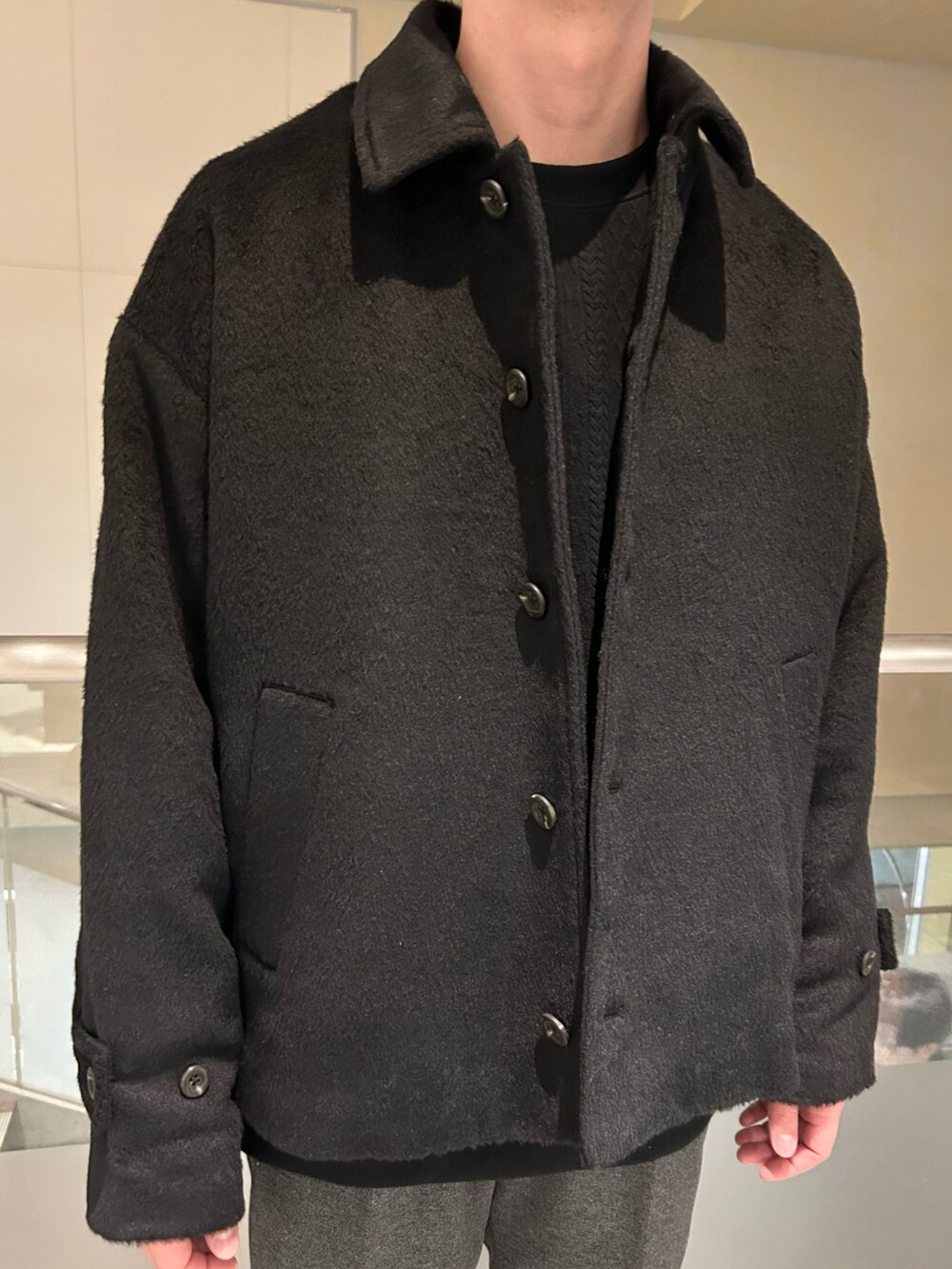 ブラック系のブルゾン、ブラック系のTシャツ/カットソー、グレー系のパンツを着用したメンズの冬コーディネートの4枚目の写真