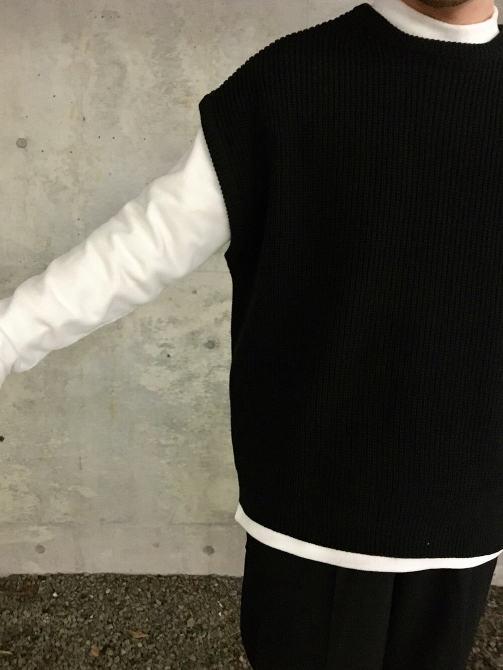 ブラック系のベスト、ホワイト系のTシャツ/カットソー、ブラック系のスラックスを着用したメンズの冬コーディネートの3枚目の写真