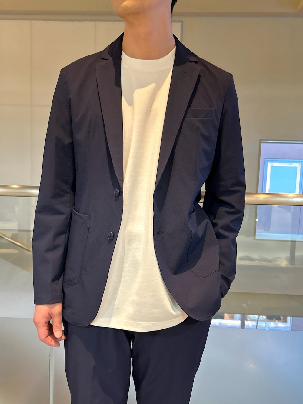 ブルー系のテーラードジャケット、ホワイト系のTシャツ/カットソー、ブルー系のスラックスを着用したメンズの春コーディネートの3枚目の写真