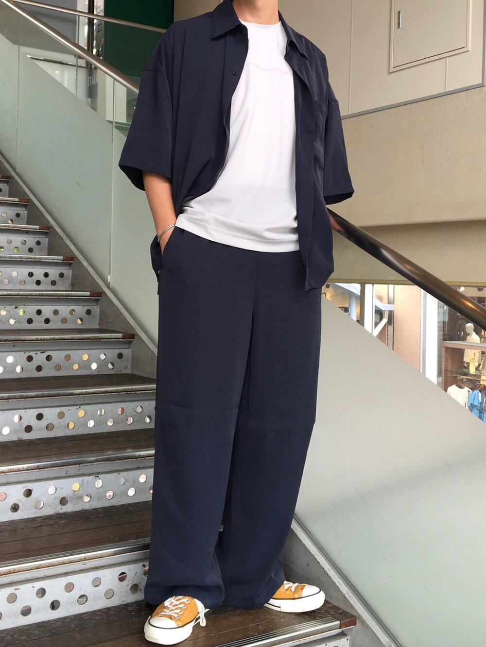 ベージュ系のTシャツ/カットソー、ブルー系のセットアップを着用したメンズの夏コーディネートの2枚目の写真