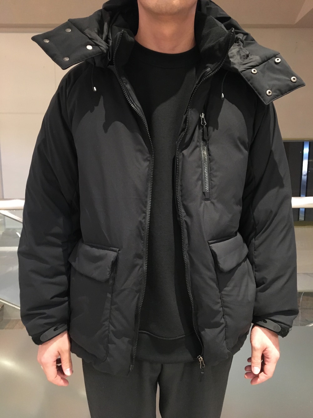 ブラック系のスウェット、ブラック系のダウンジャケット/コート、グレー系のスラックスを着用したメンズの冬コーディネートの4枚目の写真