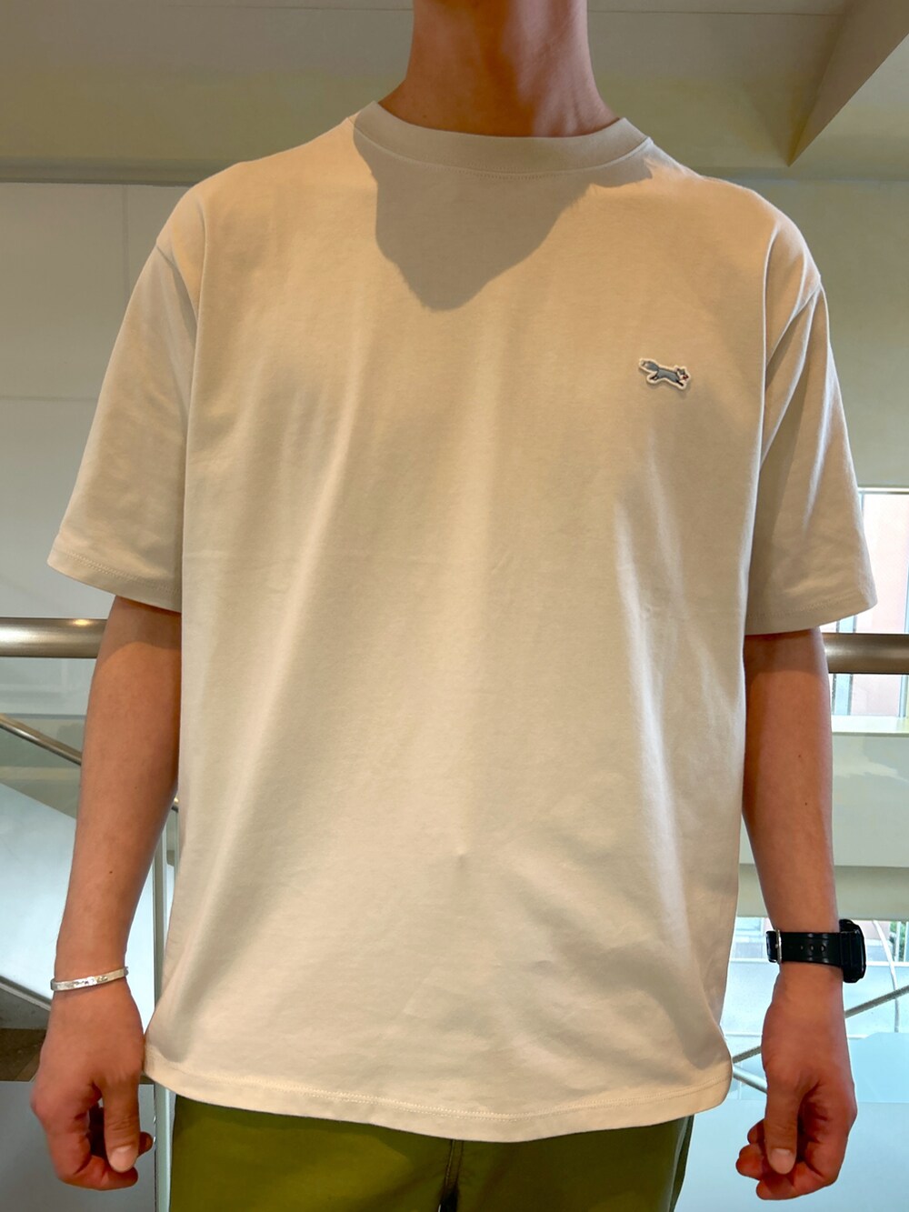 ベージュ系のTシャツ/カットソー、グリーン系のデニムパンツ、ブラック系のサンダルを着用したメンズの夏コーディネートの4枚目の写真