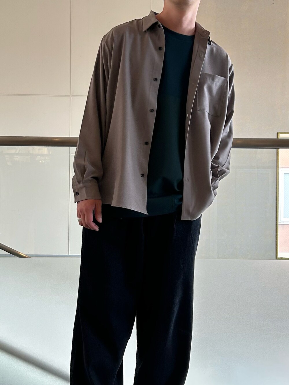 ベージュ系のシャツ/ブラウス、グリーン系のTシャツ/カットソー、ブラック系のデニムパンツを着用したメンズの秋コーディネートの2枚目の写真