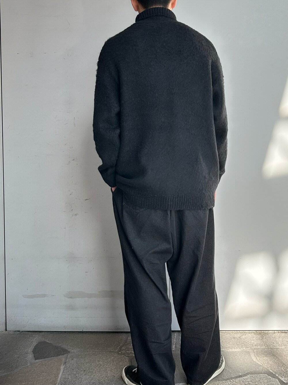 ブラック系のニット/セーター、ブラック系のデニムパンツを着用したメンズの冬コーディネートの3枚目の写真