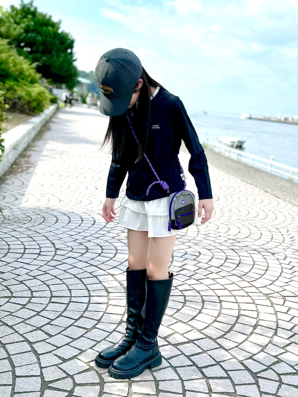 ブラック系のTシャツ/カットソー、グレー系のショルダーバッグ、ホワイト系のスカートを着用したキッズの秋コーディネートの2枚目の写真