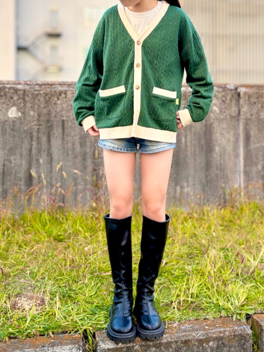 ベージュ系のTシャツ/カットソー、ブルー系のデニムパンツ、グリーン系のカーディガン/ボレロを着用したキッズの冬コーディネートの2枚目の写真