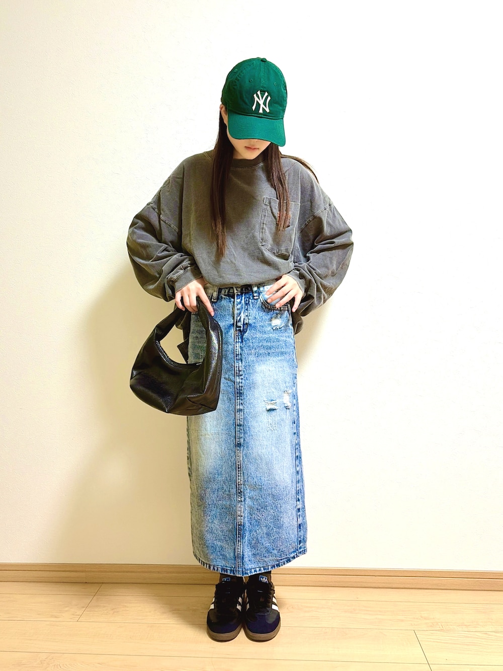 グレー系のTシャツ/カットソー、ブルー系のデニムスカート、ブラック系のハンドバッグを着用したキッズの秋コーディネートの2枚目の写真