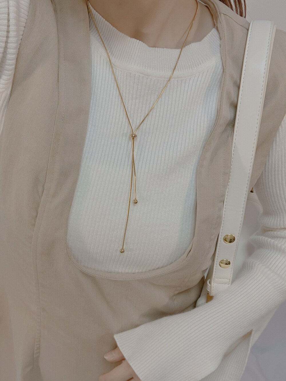 ホワイト系のシューズ、ホワイト系のショルダーバッグ、ホワイト系のニット/セーターを着用したレディースの秋コーディネートの5枚目の写真