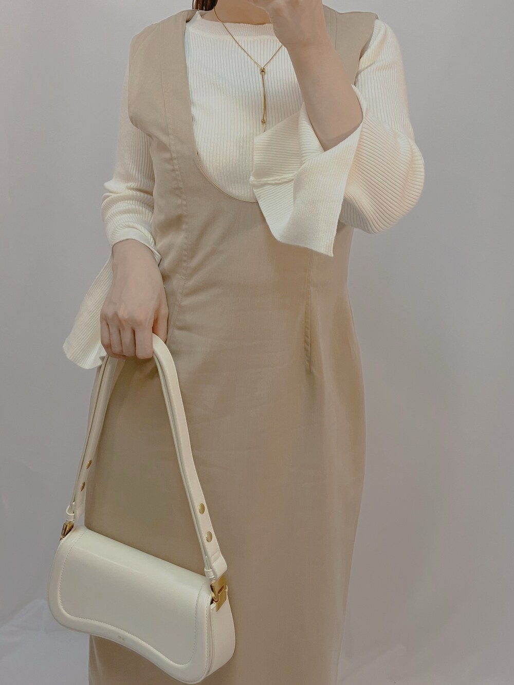 ホワイト系のシューズ、ホワイト系のショルダーバッグ、ホワイト系のニット/セーターを着用したレディースの秋コーディネートの3枚目の写真