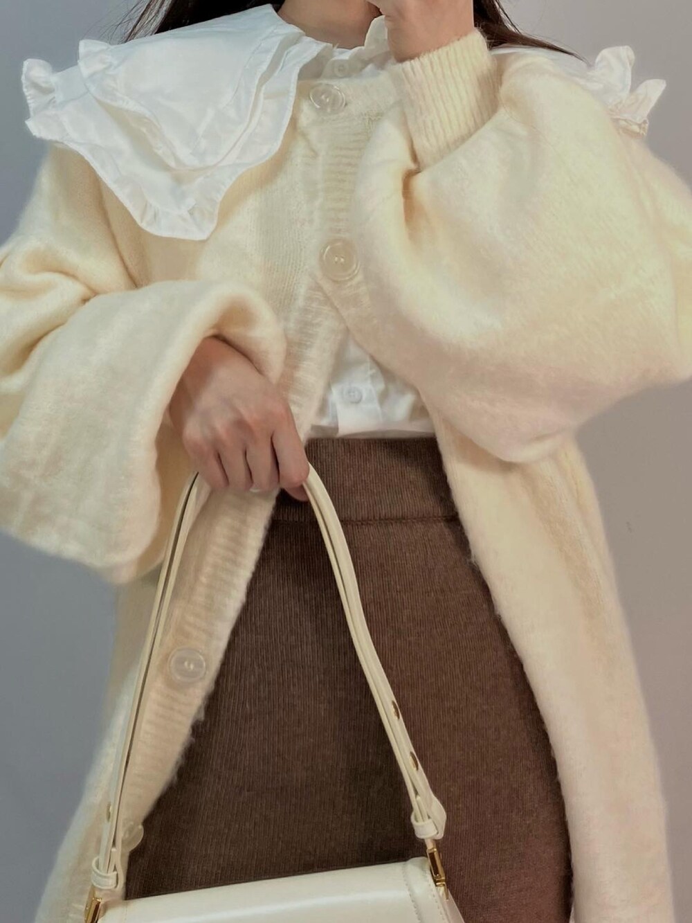 ブラウン系のスカート、ホワイト系のカーディガン/ボレロ、ホワイト系のシャツ/ブラウスを着用したレディースの秋コーディネートの3枚目の写真