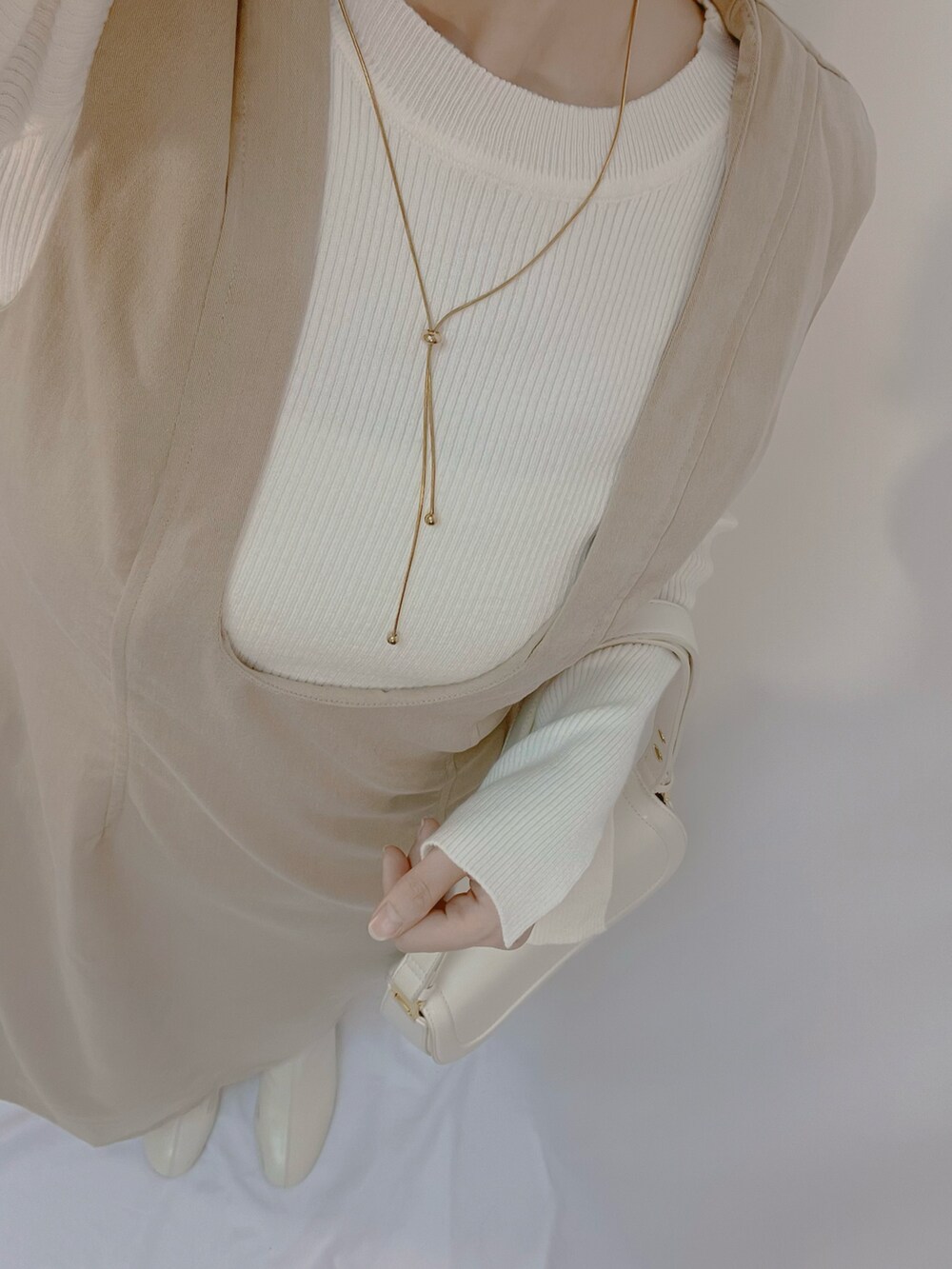 ホワイト系のシューズ、ホワイト系のショルダーバッグ、ホワイト系のニット/セーターを着用したレディースの秋コーディネートの4枚目の写真